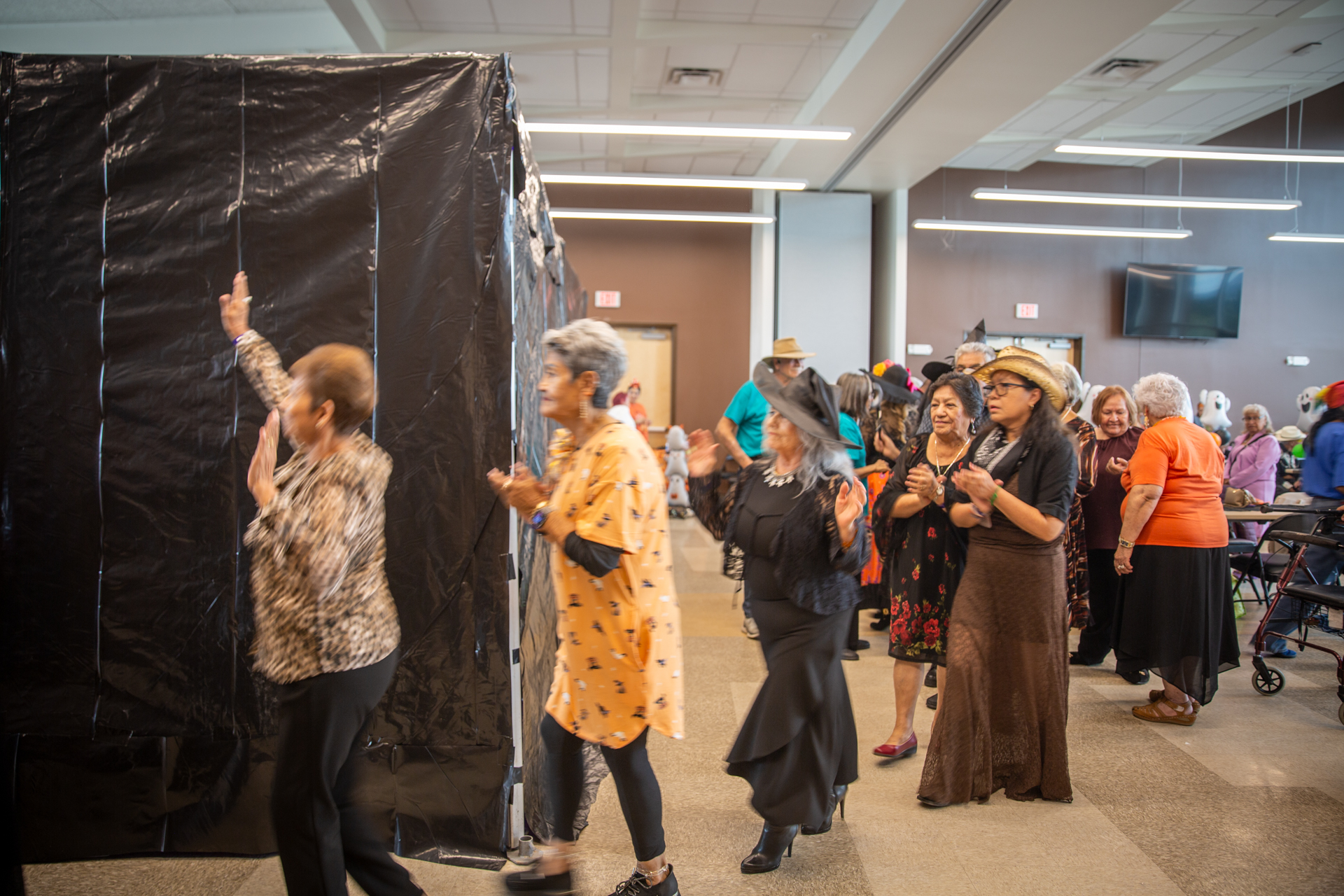 Guests gathered at the black-curtained entrance to the haunted house