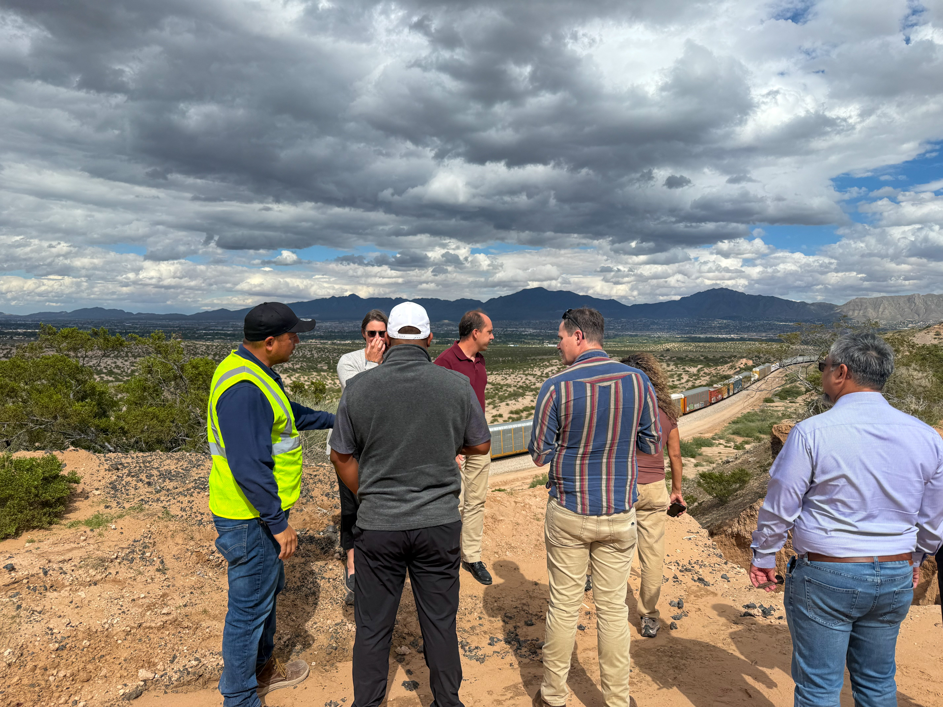 Tour participants and a crew member looking out over the valley and railroad