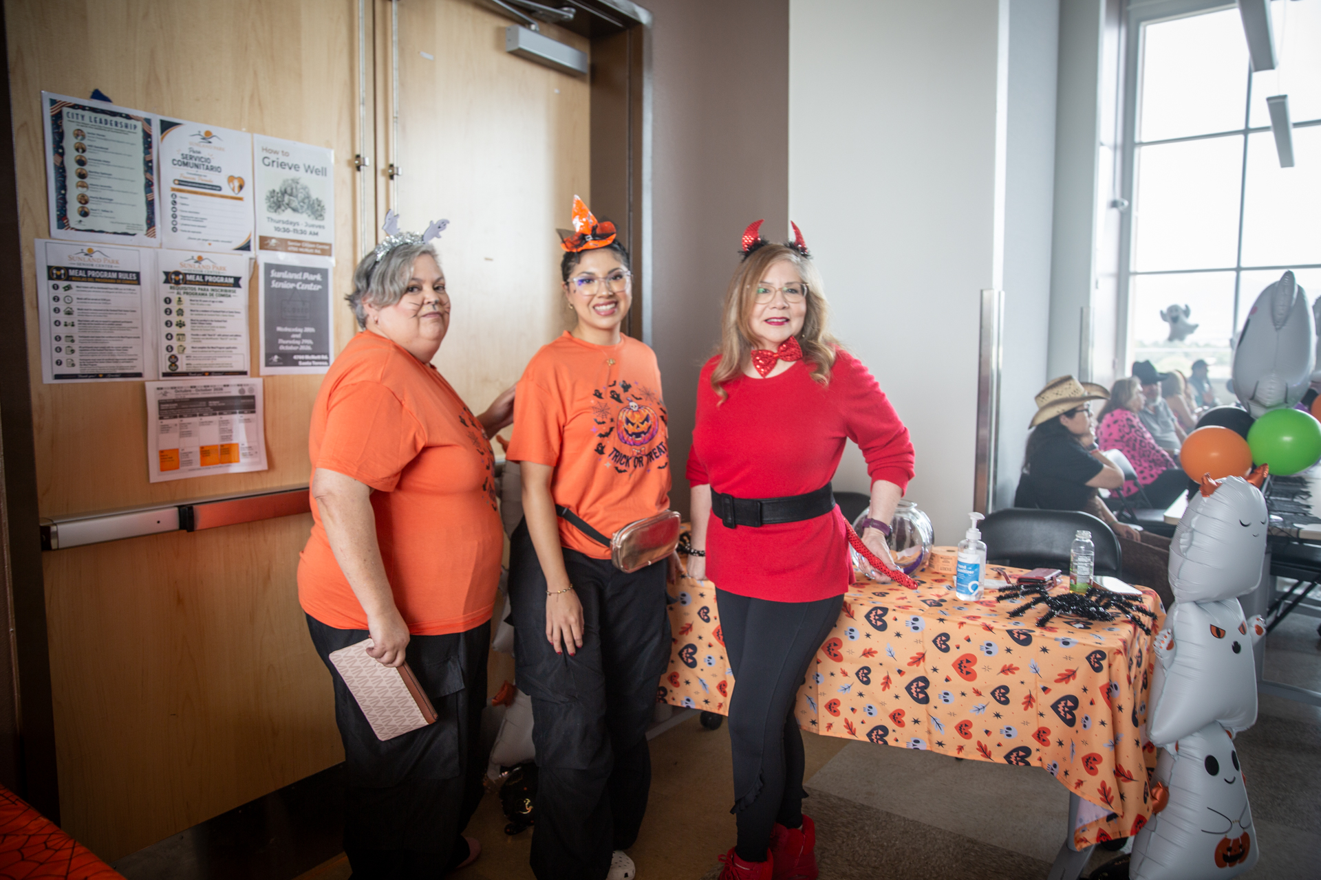 Staff in orange shirts at a table during the event