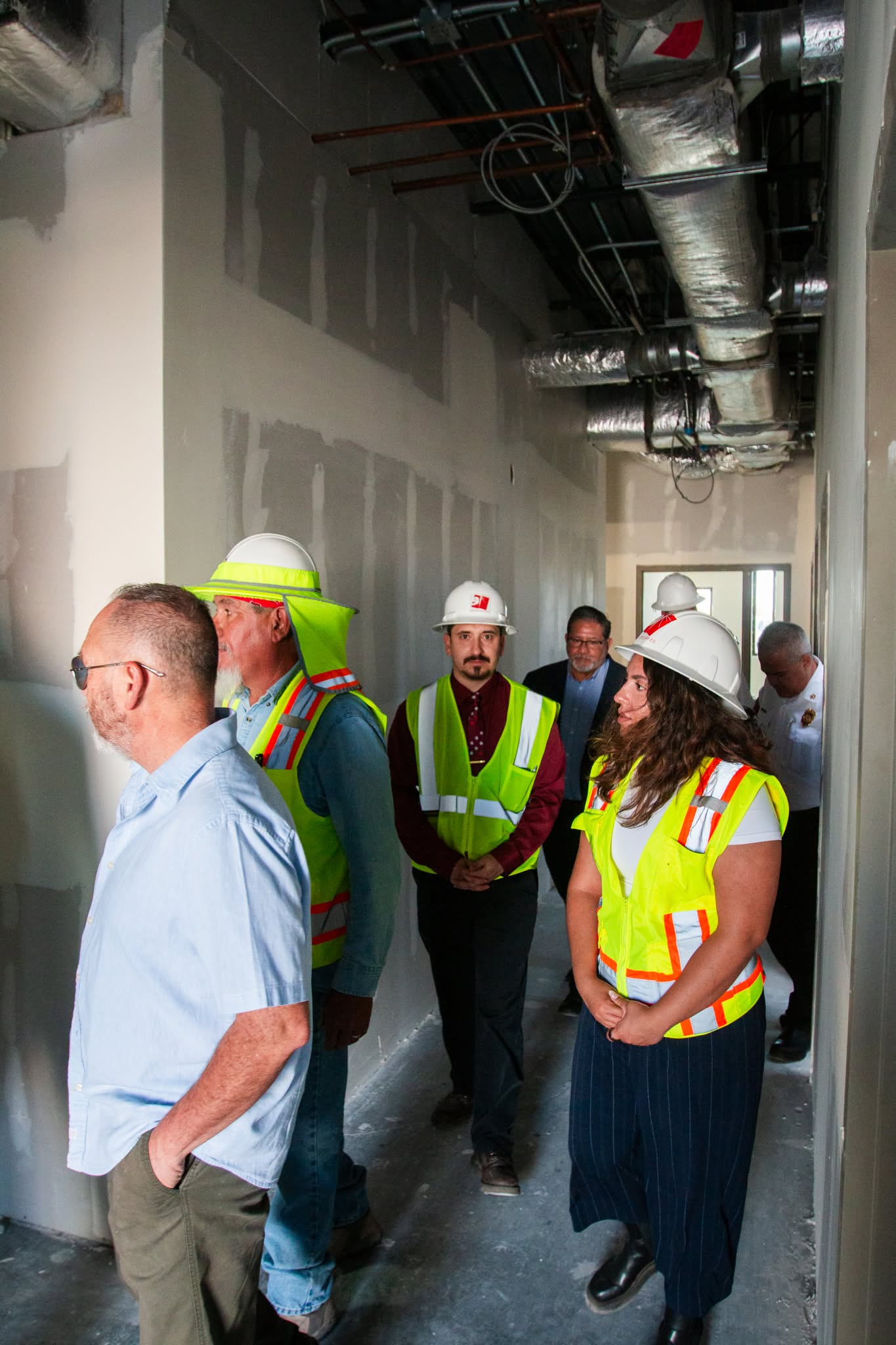 City directors and council members walking the construction site with hard hats