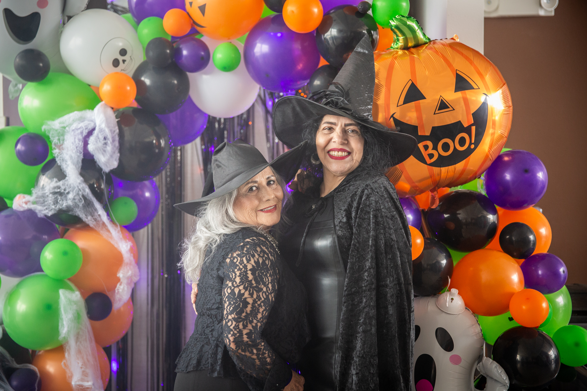 Costumed guests in front of the balloon arch with a giant pumpkin