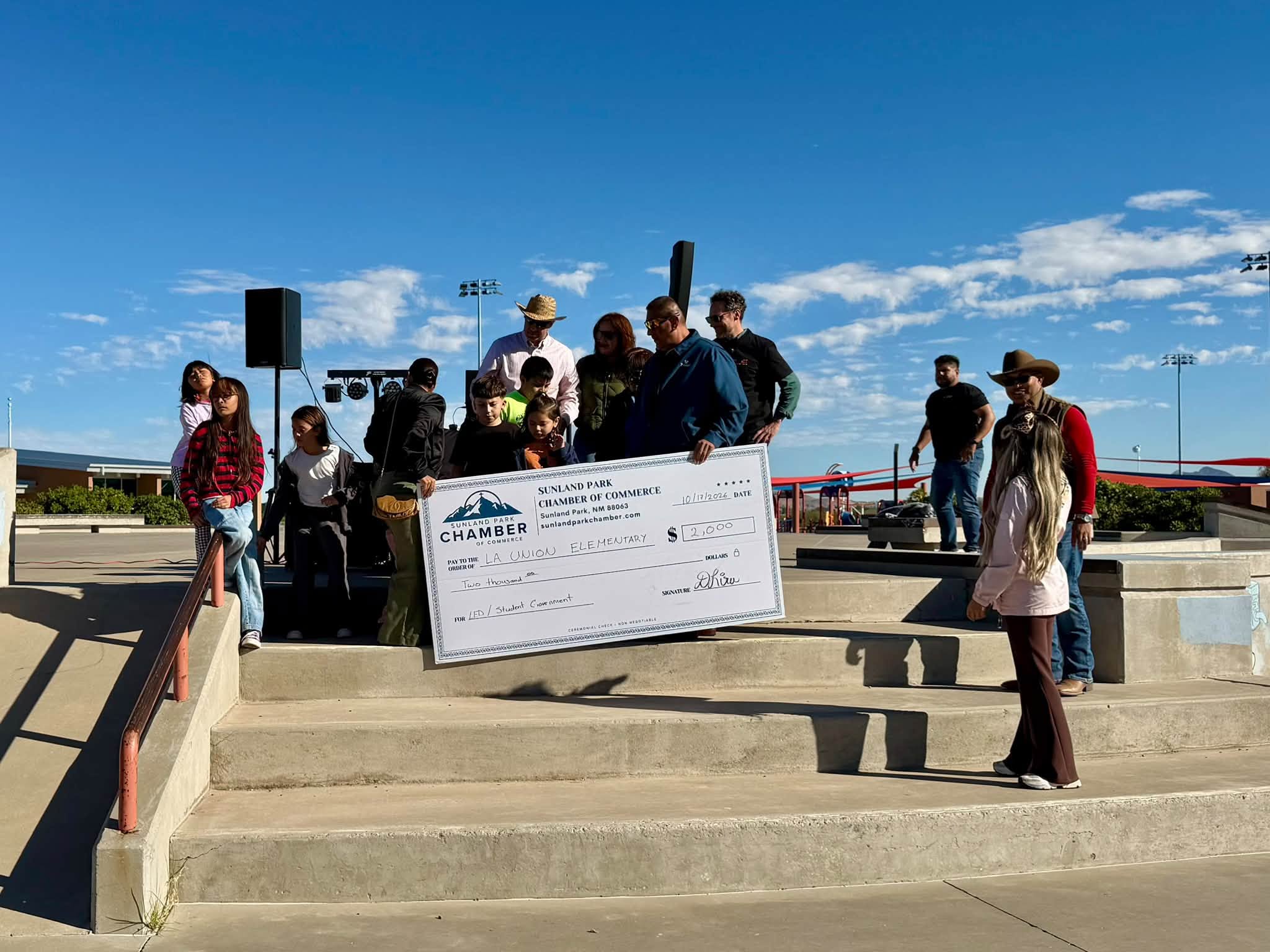 Students and community members hold a large ceremonial check made out to La Union Elementary