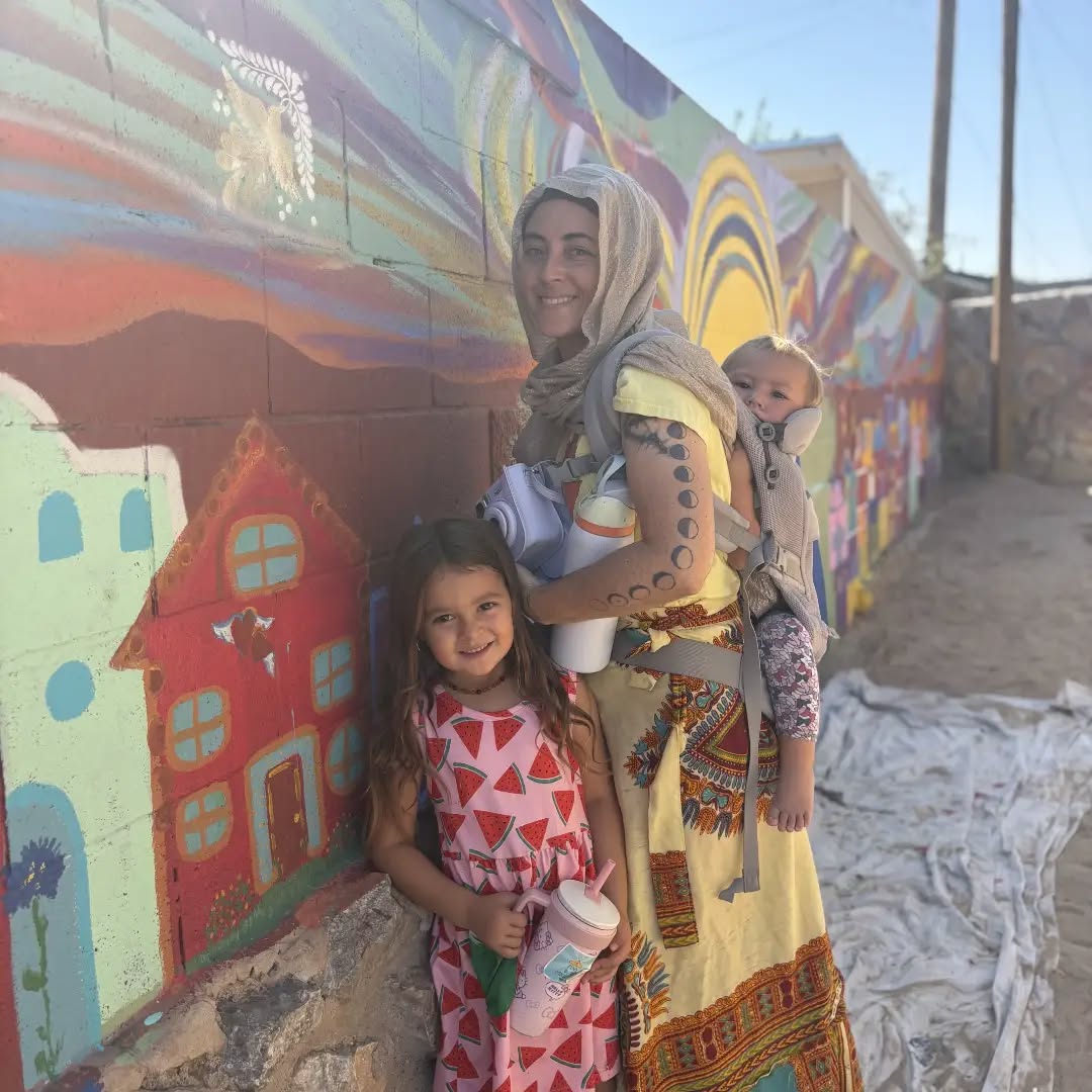 A family stands in front of the mural.