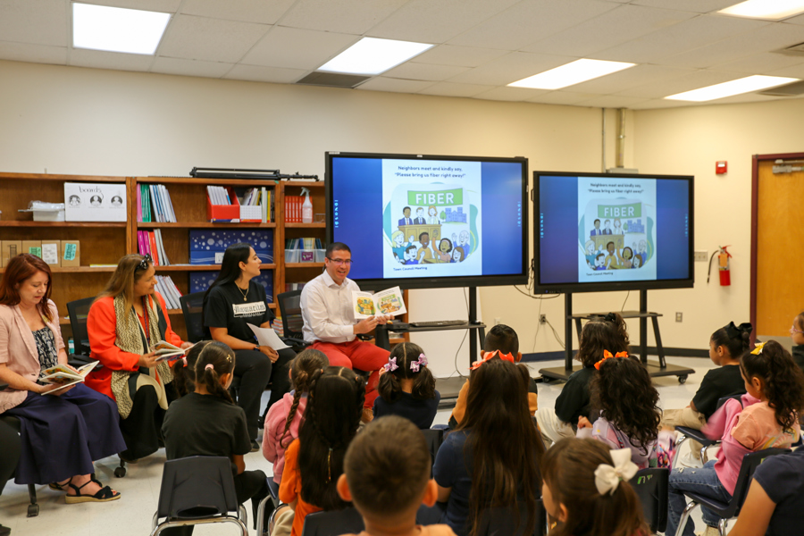 Mayor Perea shares a page of the book with students.