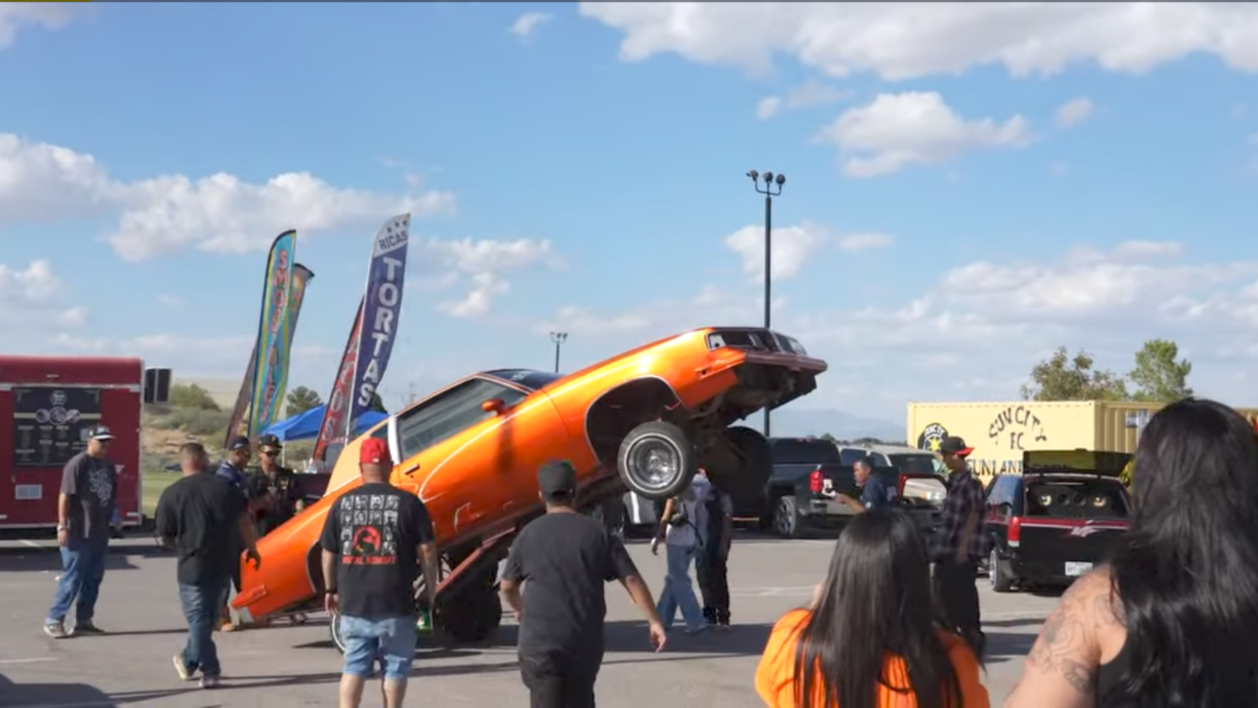 An orange lowrider lifts its front end during the hop contest